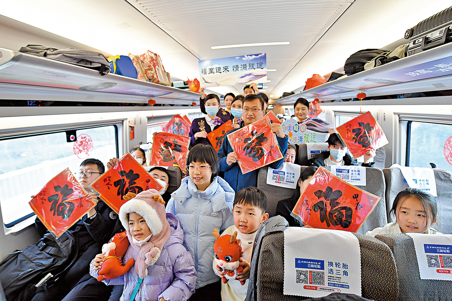 　　圖：2024年春運首日，在由南京南站發往太倉的G8981次列車上，工作人員與旅客手持福字合影留念。\新華社