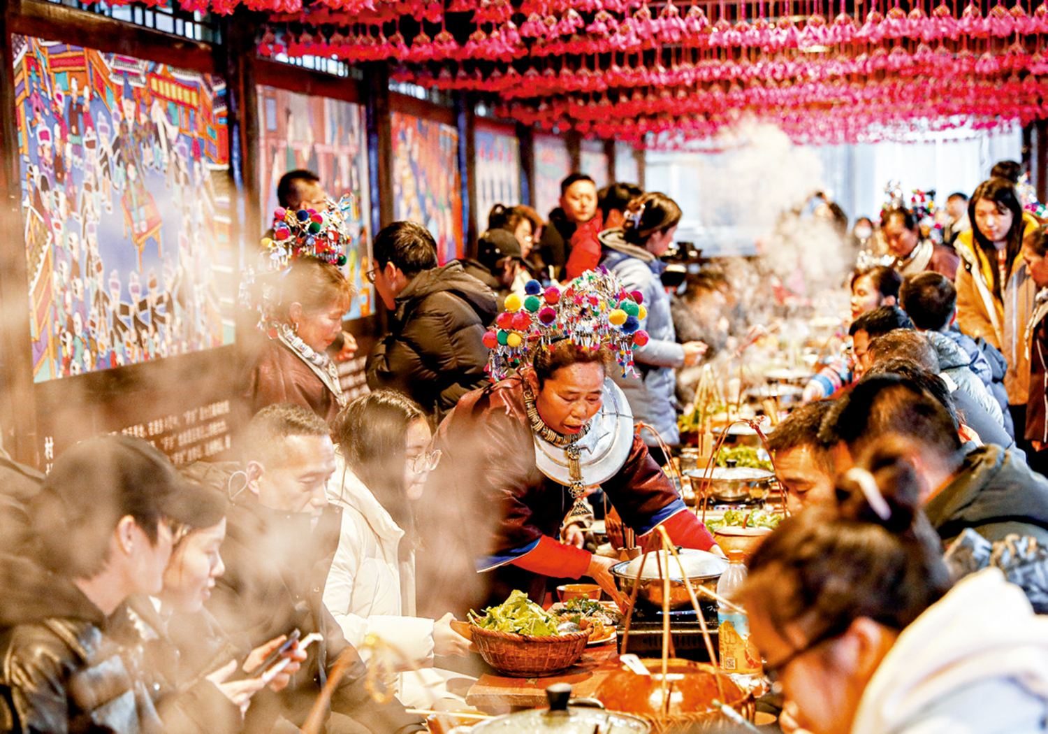 　　圖：1月28日，在廣西柳州三江侗族自治縣程陽八寨景區，遊客在體驗侗族百家宴。\新華社