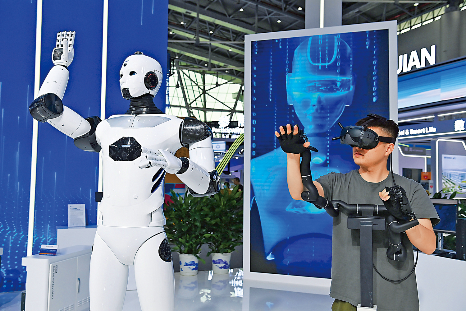　　圖：參觀者在合肥世界製造業大會上體驗智能抓取機器人。\中新社