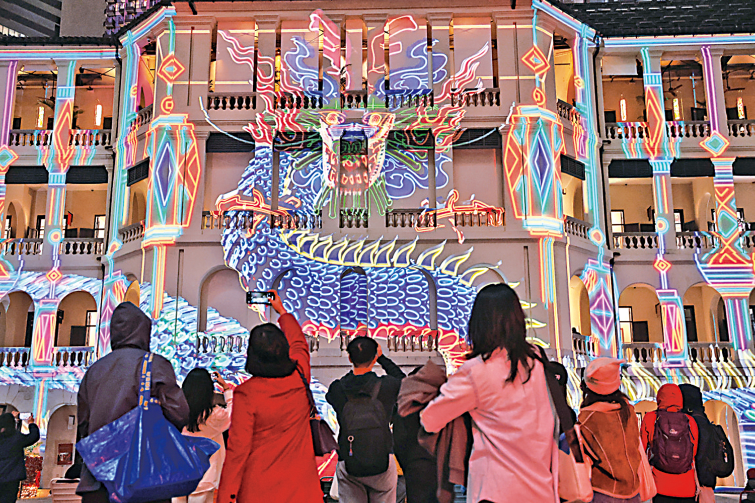 　　圖：踏入龍年之際，香港中環大館立體光雕投影節目《綻放大館》再度回歸，今年以《龍之歌》作主軸，巨龍投影在檢閱廣場「穿插」，猶如活生生的彩色巨龍，吸引大批市民前往觀看，為農曆新年添上節日氣氛。\香港中通社