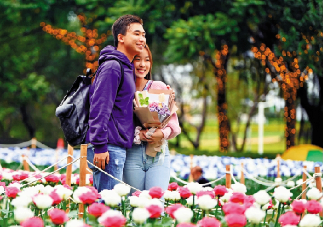 　　圖：情侶在公園捧花享受甜蜜時光。\中新社