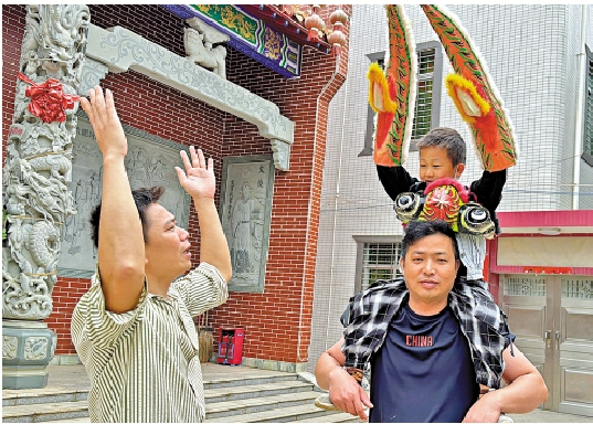 　　圖：湛江人龍舞市級非遺傳承人王宏偉在指導小兒子扮演「龍頭」。\大公報記者黃寶儀攝