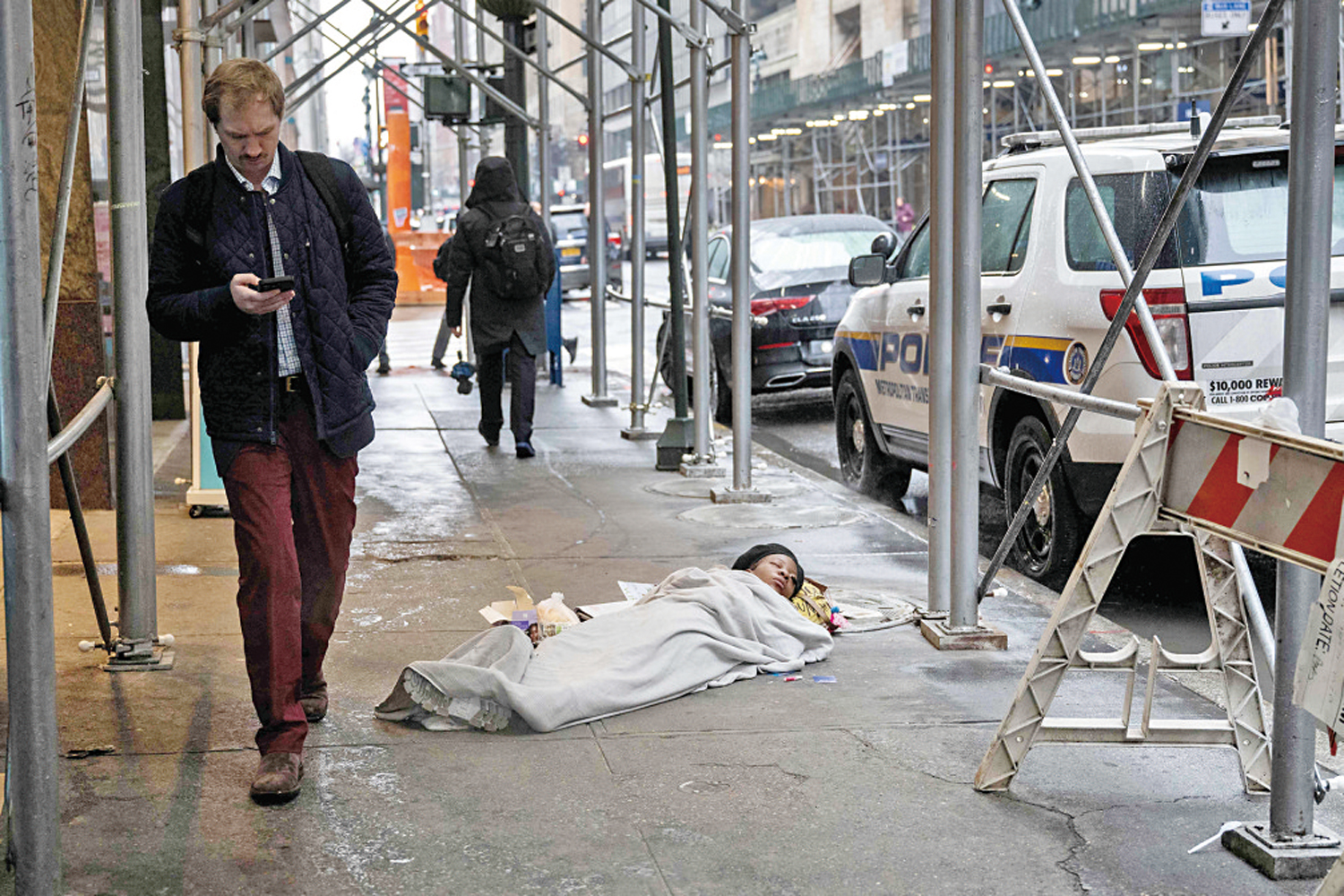 　　圖：1月，一名無家可歸者露宿紐約人行道。\法新社