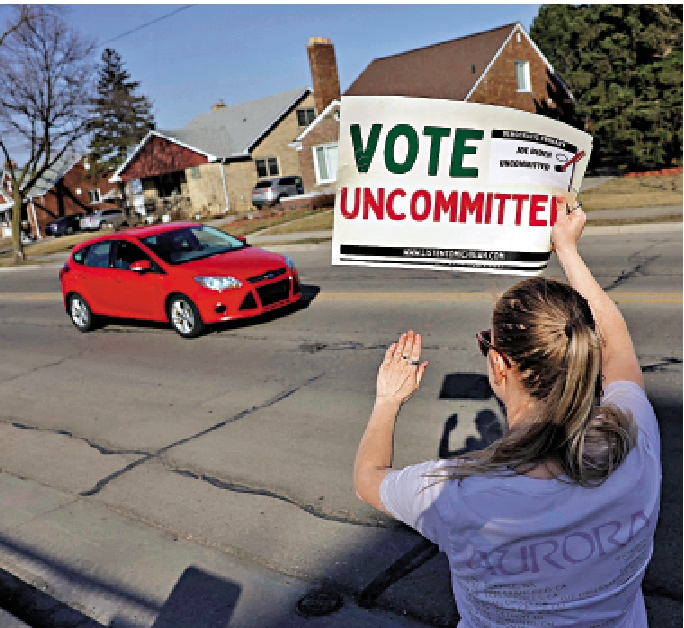 　　圖：密歇根州一名不支持拜登的民主黨選民27日在票站外高舉「選擇不表態」的紙牌。\法新社