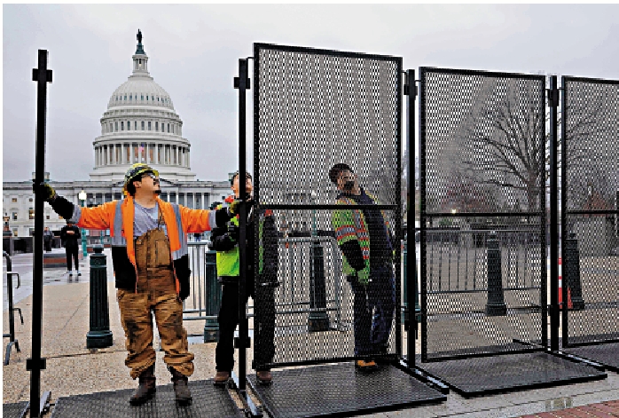 　　圖：拜登於7日發表國情咨文演講，工人6日在國會大廈周圍豎起鋼製圍欄。\法新社