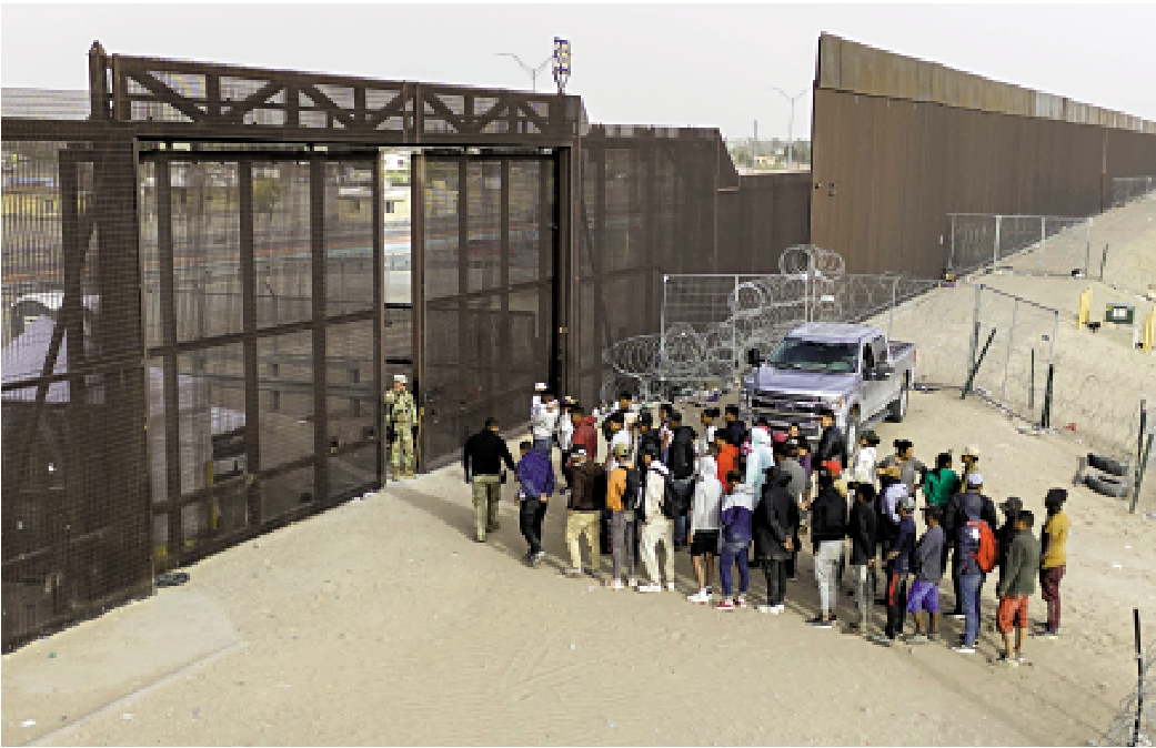 　　圖：非法移民在得州邊境等待美國執法人員處理。\法新社