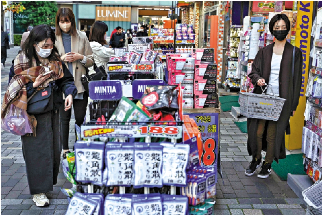 　　圖：日本民眾在東京市中心的一家藥房連鎖店外觀看商品。\法新社