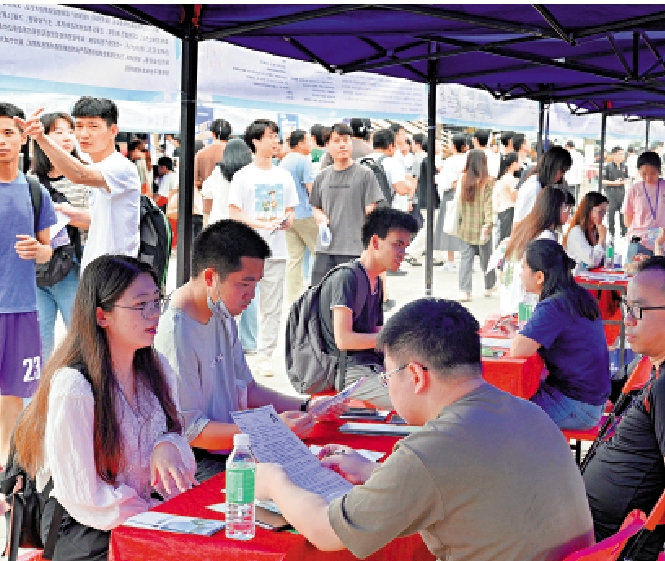　　圖：3月30日，廣東工業大學學生和招聘單位工作人員交流。\中新社