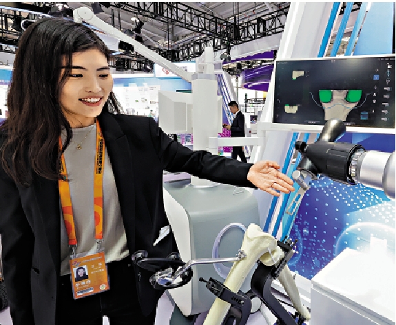 　　圖：在2023年服貿會上，工作人員向民眾介紹膝關節手術機器人。\新華社