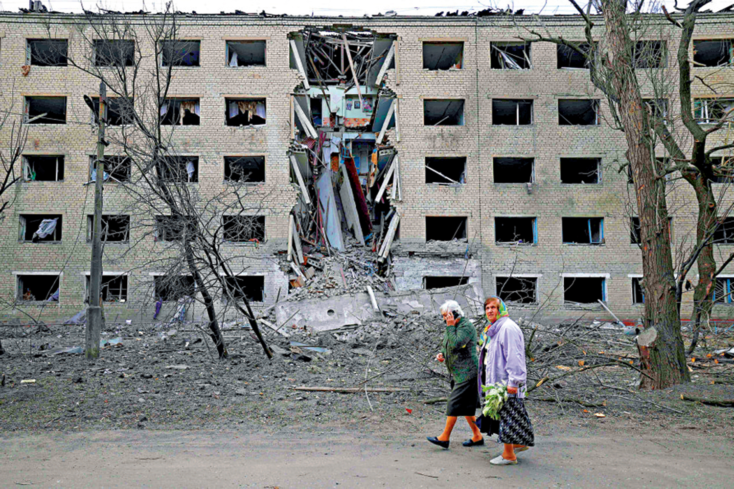　　圖：烏克蘭民眾14日走過一棟被導彈炸毀的建築。\法新社