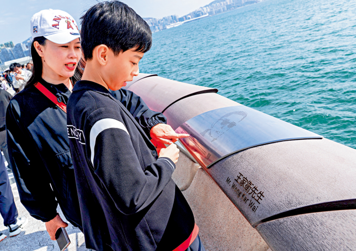 　　圖：在香港星光大道，遊客仔細查看著名導演王家衛的手印。\中新社