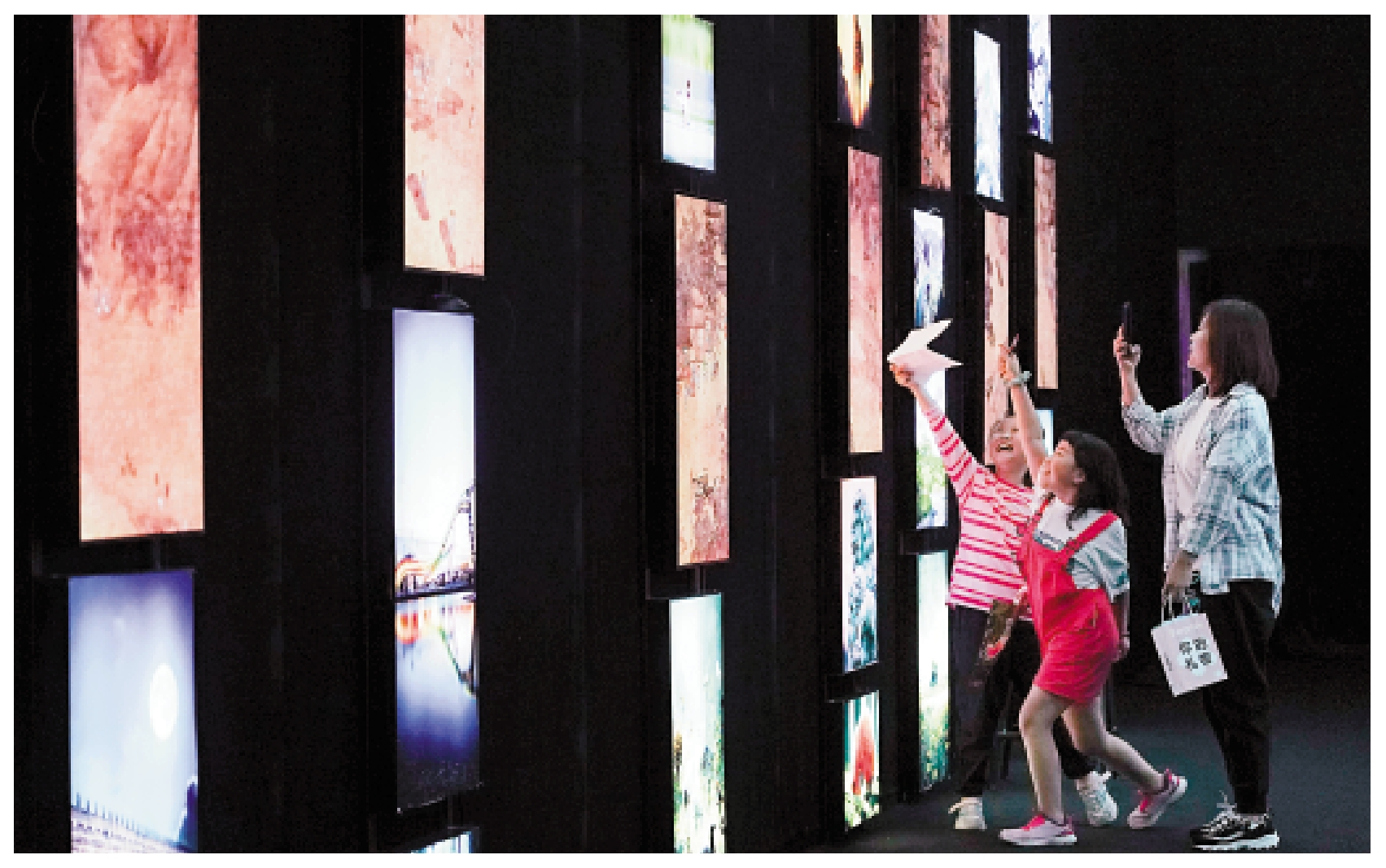 　　圖：在位於北京市石景山區首鋼園的瞭倉數字藏品博物館，觀眾在一間以永定河生態為主題、展示動態畫作、實景照片和人工智能生成畫作的展廳裏參觀。\新華社
