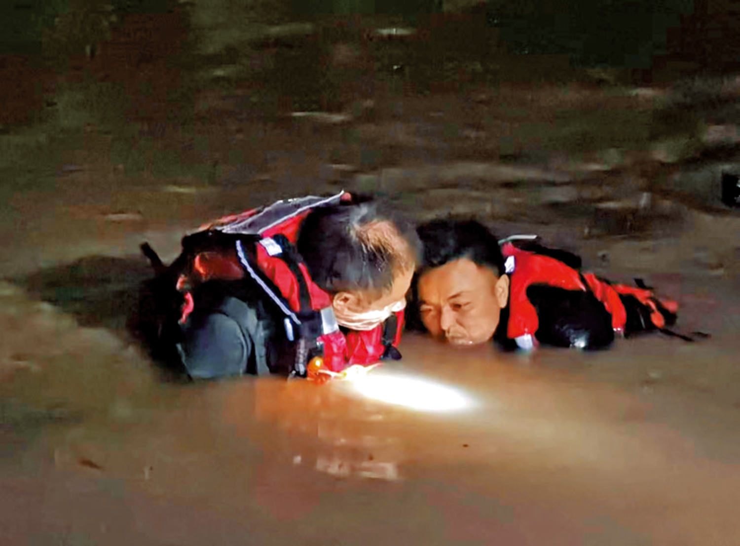 　　圖：鄧占榮（右）正在河水中作業。