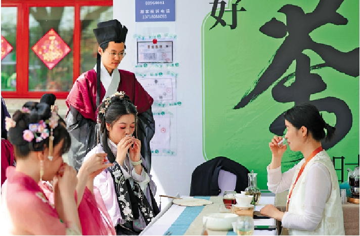 　　圖：身着漢服的女孩在北京舉行的八大處中國園林茶文化節攤位前品茶。/中新社