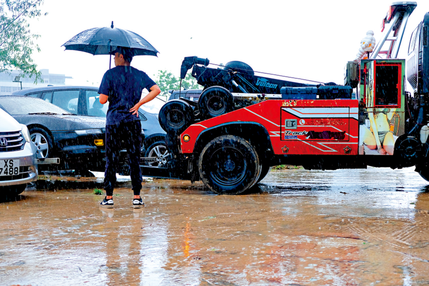 　　圖：有車主召拖車拖走被泥水淹浸的愛車。\大公報記者蔡文豪攝