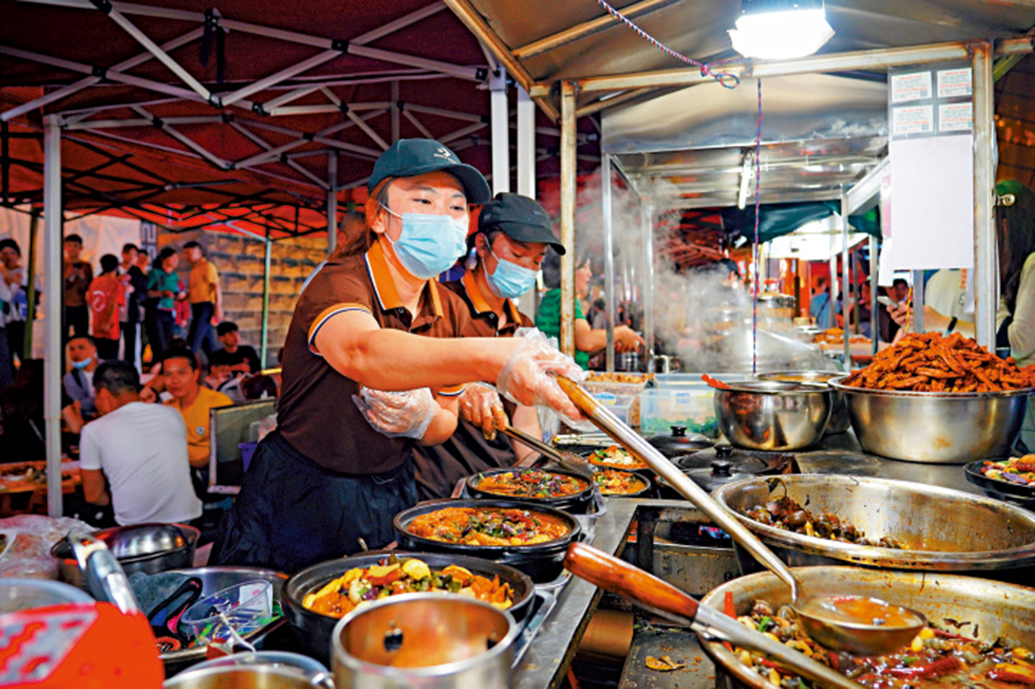 　　圖：在廣西柳州，攤主正在製作廣西特色小吃螺螄鴨腳煲。\中新社