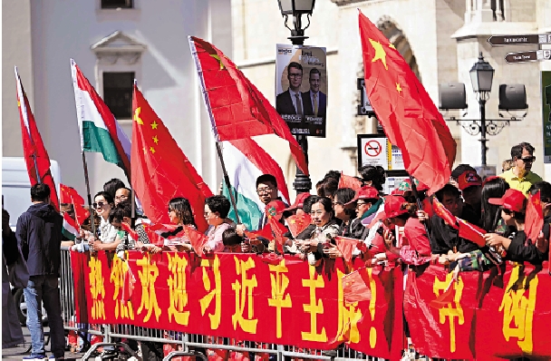　　圖：當地時間5月9日，群眾在布達佩斯總統府附近街頭舉着中國國旗，歡迎習近平主席到訪。\法新社