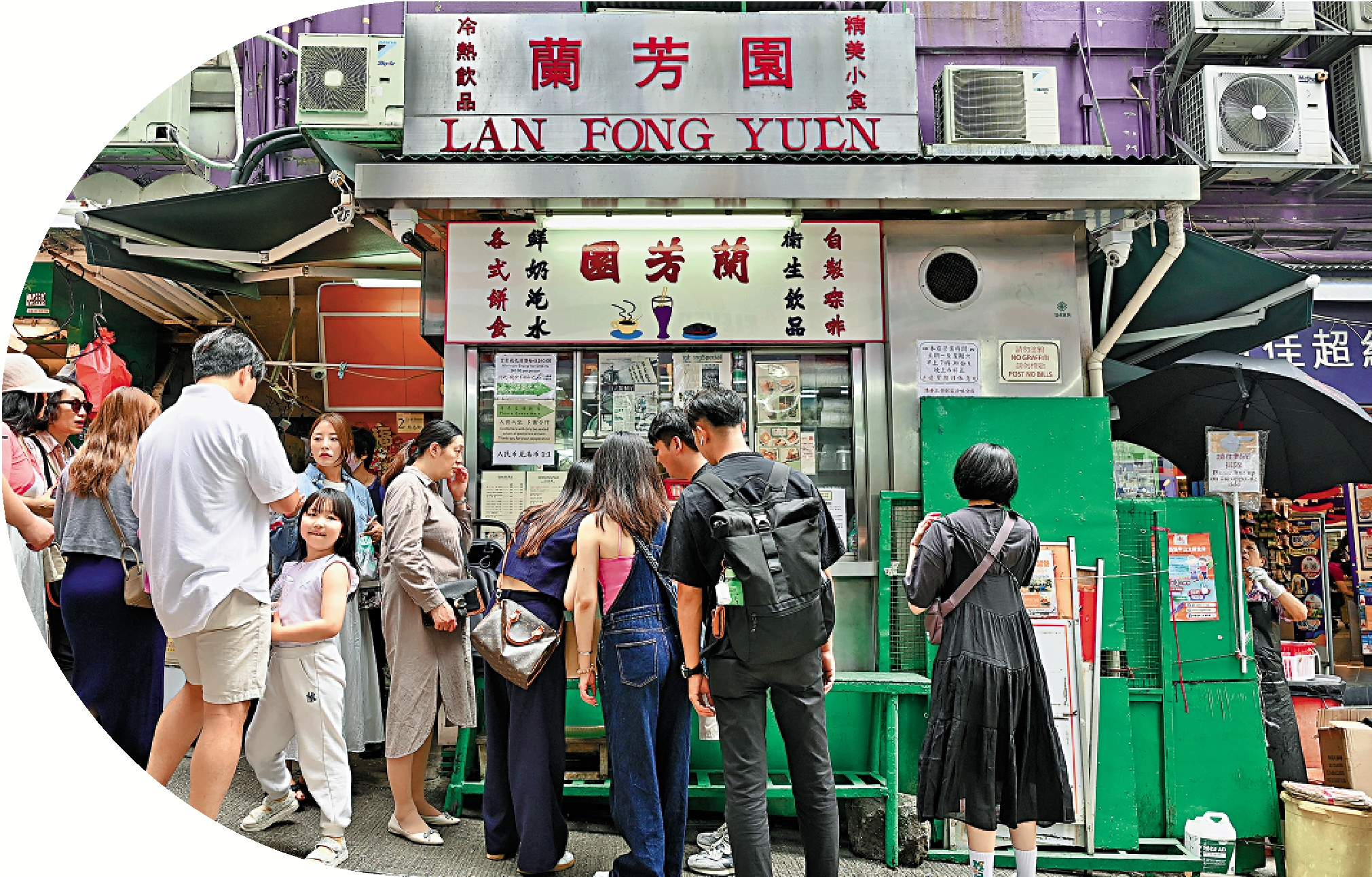 　　圖：5月10日，內地訪港旅客於中環石板街附近遊覽。圖為遊客購買香港特色「絲襪奶茶」飲品。/中新社