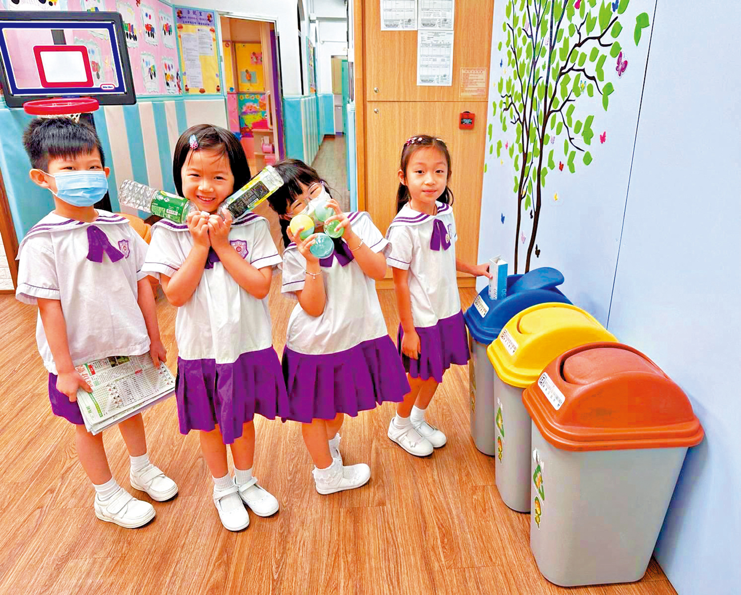 　　圖：荃灣商會朱昌幼稚園的小朋友們，將垃圾分類並投入不同的回收桶。