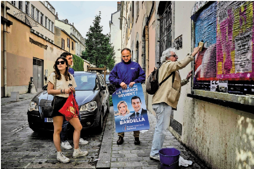 　　圖：國民聯盟志願者在里昂街頭張貼巴爾德拉的競選海報。/法新社