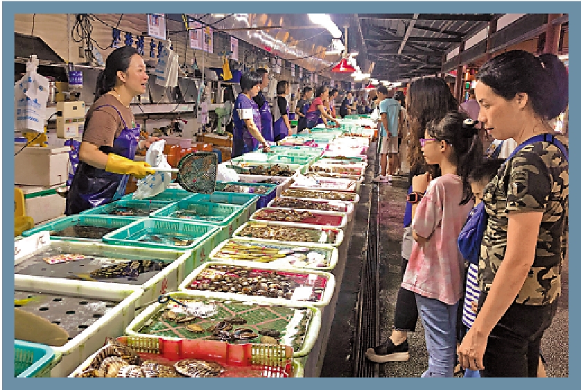 　　圖：遊客在珠海灣仔海鮮街挑選水產品。\大公報記者方俊明攝