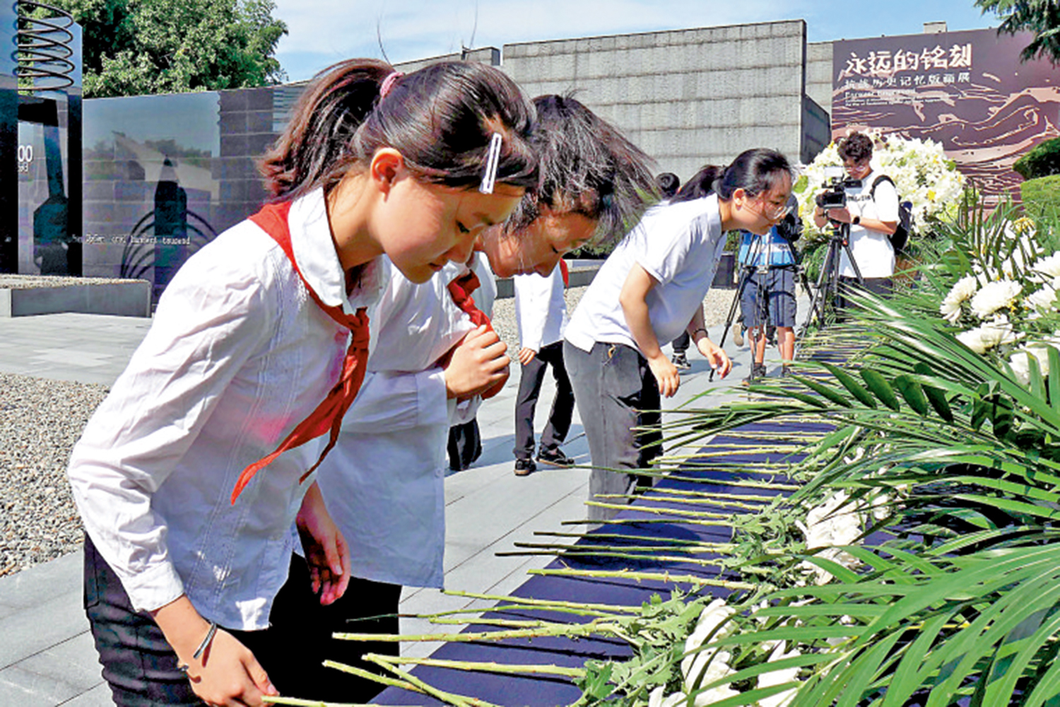 圖:南京小學生向抗戰先烈和遇難同胞獻花。\大公報記者賀鵬飛攝