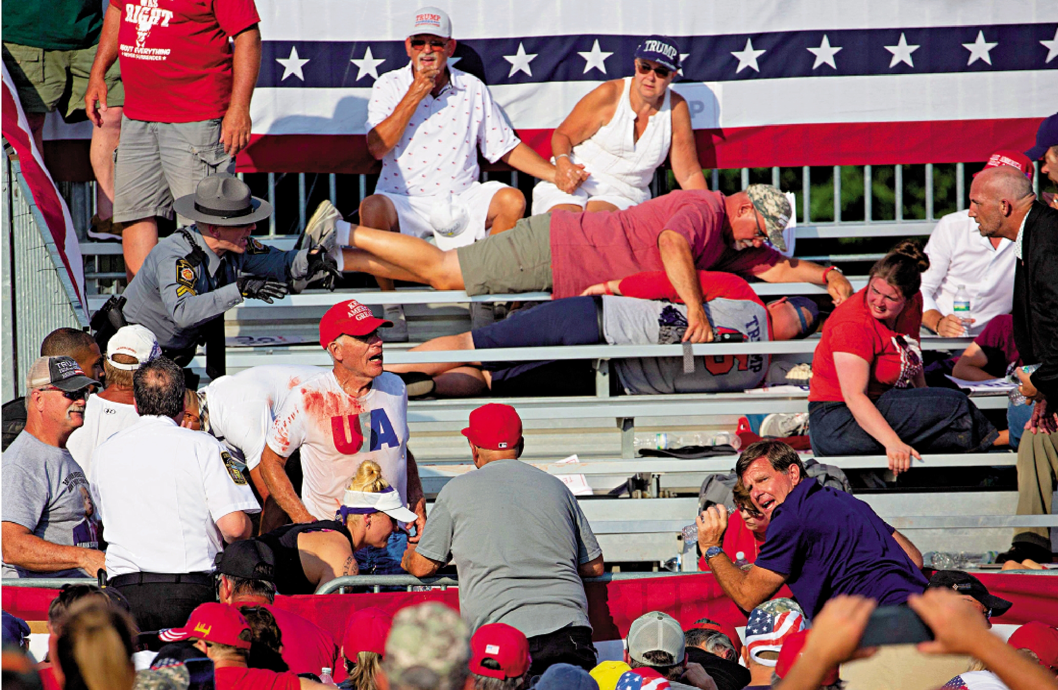 　　圖：美國前總統特朗普13日出席拉票活動時遭遇槍擊，圖為觀眾慌忙躲避子彈。\法新社