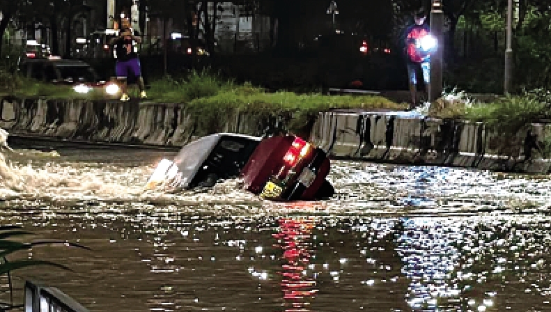 　　圖：的士墮入巨坑，幾乎被「洪水」淹沒。