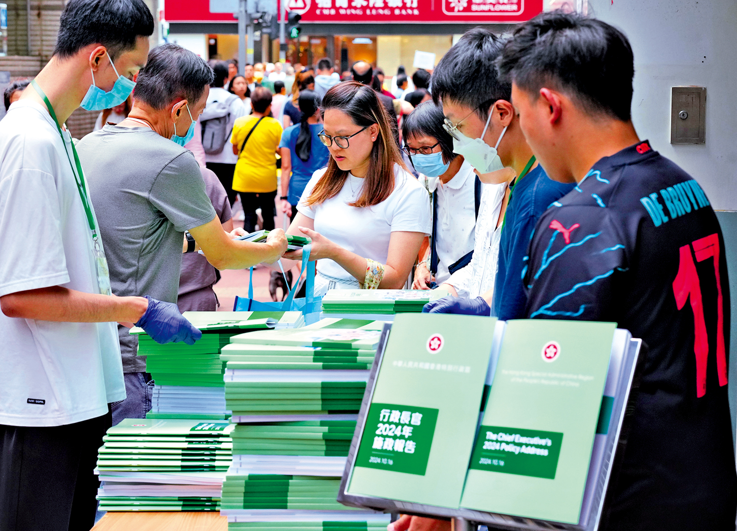 　　圖：行政長官李家超昨日發表《2024年施政報告》，大批市民在各區派發點排隊領取紙本報告。\大公報記者林良堅攝