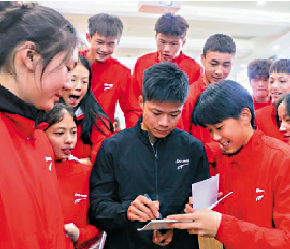 　　圖：蘇炳添（前右二）為年輕運動員簽名。