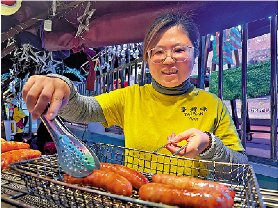 　　圖：張素萍在哈爾濱創業，為顧客烤製香噴噴的台灣烤腸。\大公報記者于海江攝