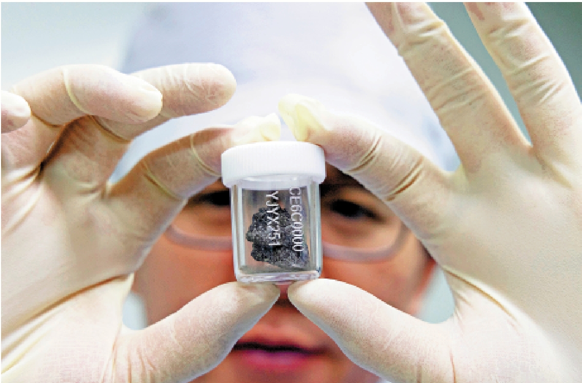 　　圖：科研人員在月球樣品實驗室展示嫦娥六號月球樣品。\新華社