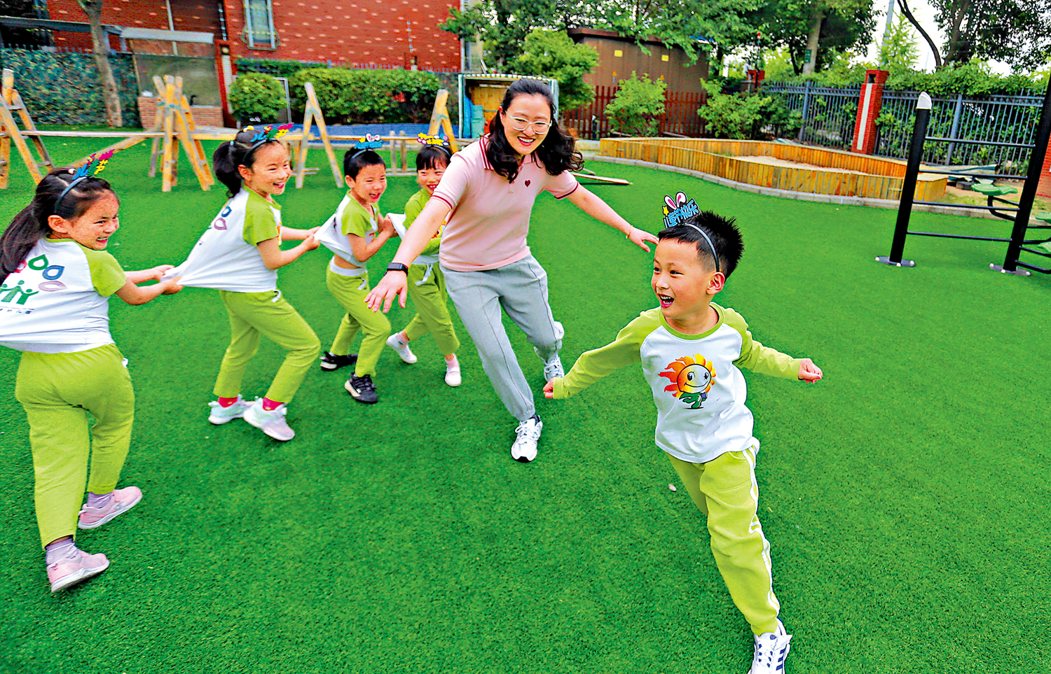 　　圖：學前教育是國民教育體系的重要組成部分，是重要的社會公益事業。圖為在揚州大學附屬西郡幼兒園，小朋友和老師玩「老鷹捉小雞」遊戲。\新華社