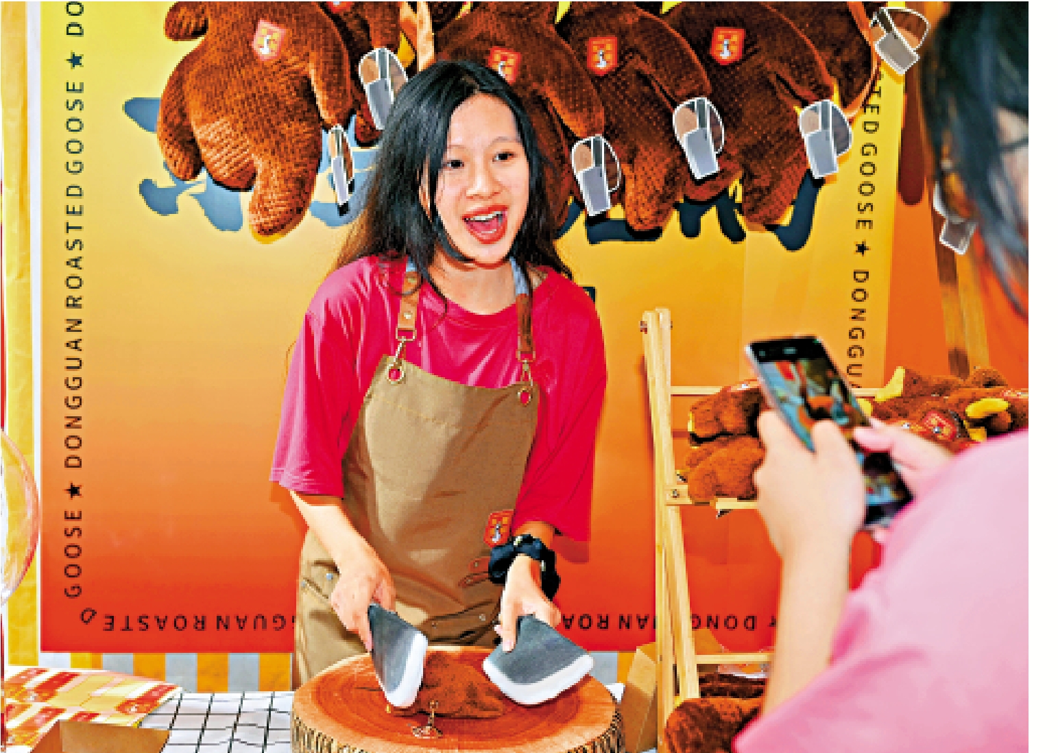 　　圖：在第十四屆中國國際影視動漫版權保護和貿易博覽會上，工作人員為顧客「切」燒鵝毛絨玩具。/中新社