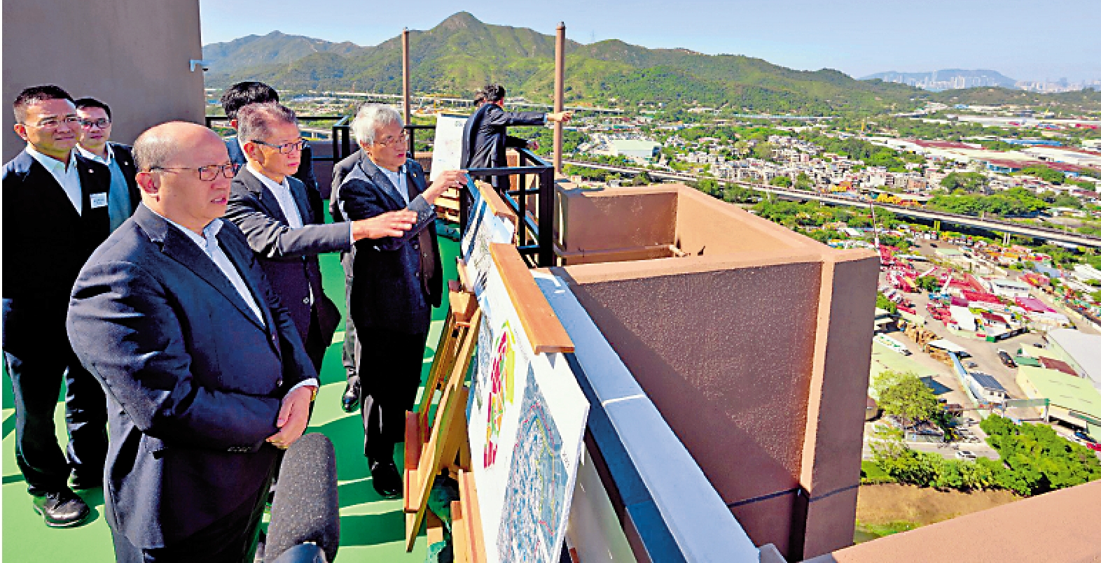 　　圖：中央政府駐港聯絡辦主任鄭雁雄、財政司司長陳茂波、政府官員及企業代表在房協洪水橋／厦村新發展區，聽取房協主席凌嘉勤的介紹。