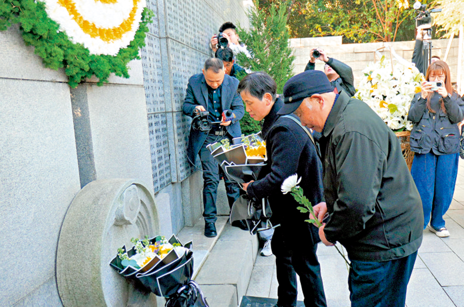 　　圖：南京大屠殺倖存者劉民生老人和女兒向遇難親人和同胞獻花。\大公報記者賀鵬飛攝