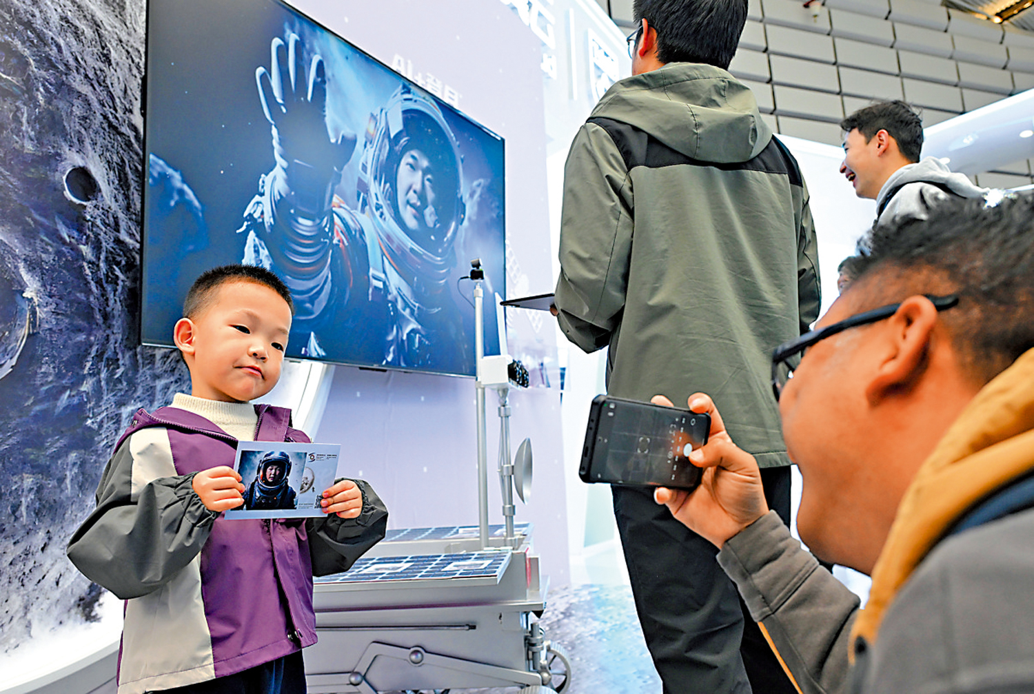 　　圖：11月19日，在2024年世界互聯網大會「互聯網之光」博覽會上，一名小觀眾同AI系統生成的本人虛擬照片合影。\新華社