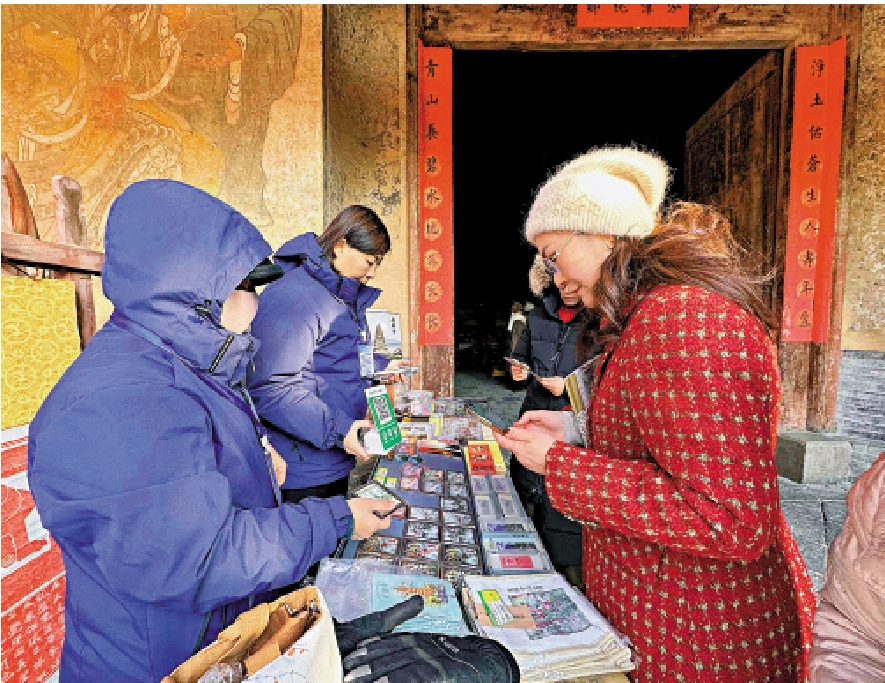 　　圖：在山西廣勝寺，海外華媒參訪團成員購買文創產品。