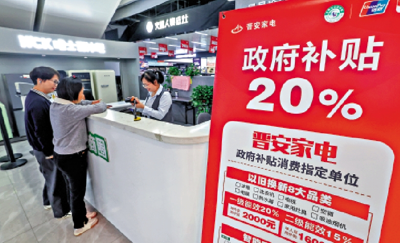 圖:顧客在浙江杭州一商場收銀台前辦理政府家電以舊換新補貼申領手續。\新華社