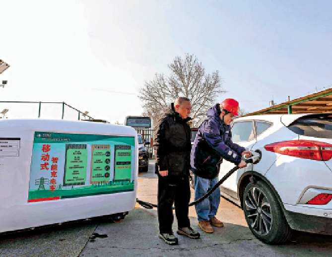 圖:1月23日,技術人員在京藏高速百葛服務區幫助市民使用「汽車充電寶」給汽車充電。\新華社