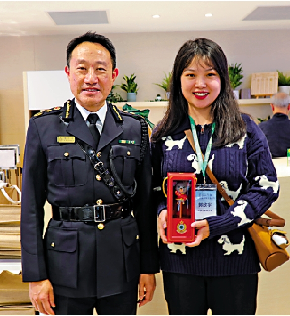 圖:學子們驚喜地收到了香港海關送出的生肖紀念品。圖為學子攜紀念品與香港海關關長陳子達合影留念。/大公報記者王月攝