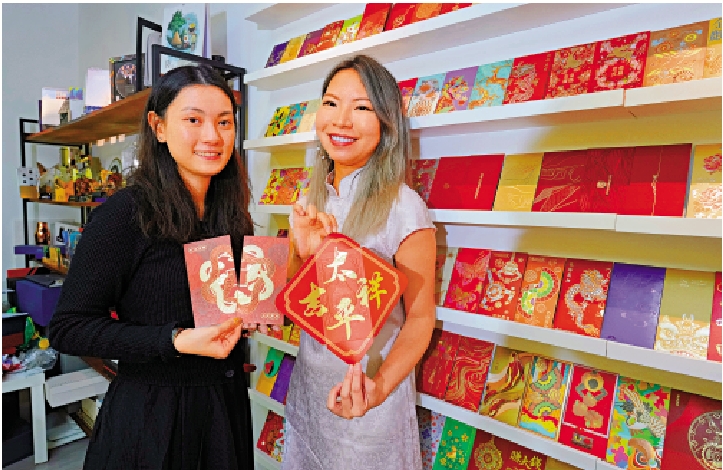 　　圖：商業禮品公司的黃思思（右）和余倩忻（左）介紹利是封的新材料和新設計元素。