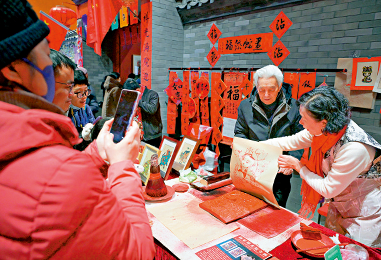 　　圖：展者在展覽上體驗「木版年畫」製作技藝。\新華社