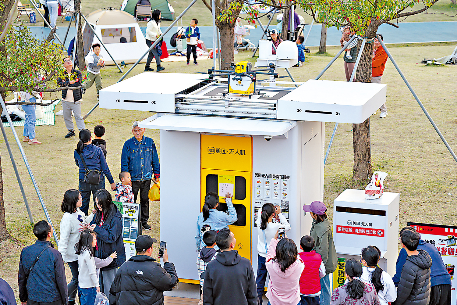 圖:深圳近日發布四批「城市+AI」應用場景清單,涵蓋城市治理、公共服務等近200個應用場景。圖為人們在深圳筆架山公園裏體驗無人機送外賣。\新華社