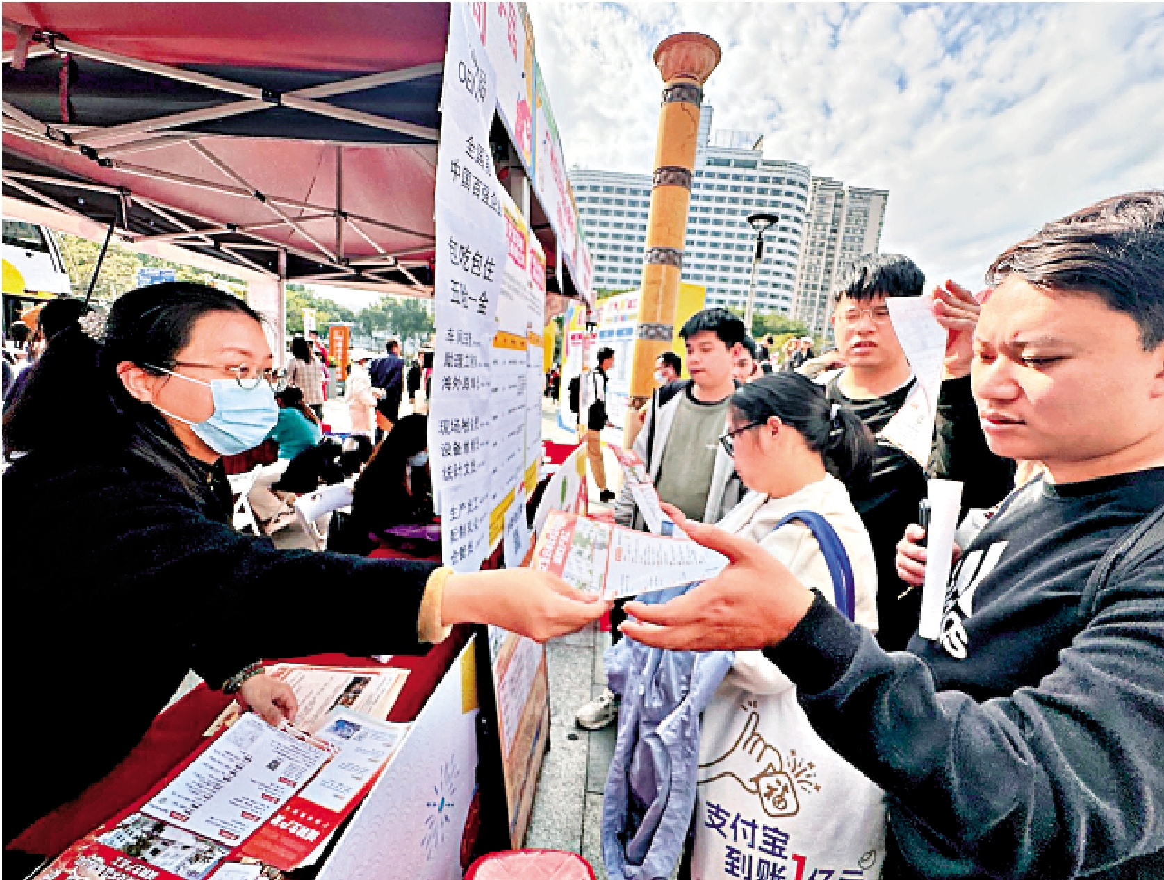 圖:11日,在廣州新春首場大型招聘會現場,某公司招工負責人派發招工宣傳單。\大公報記者李紫妍攝