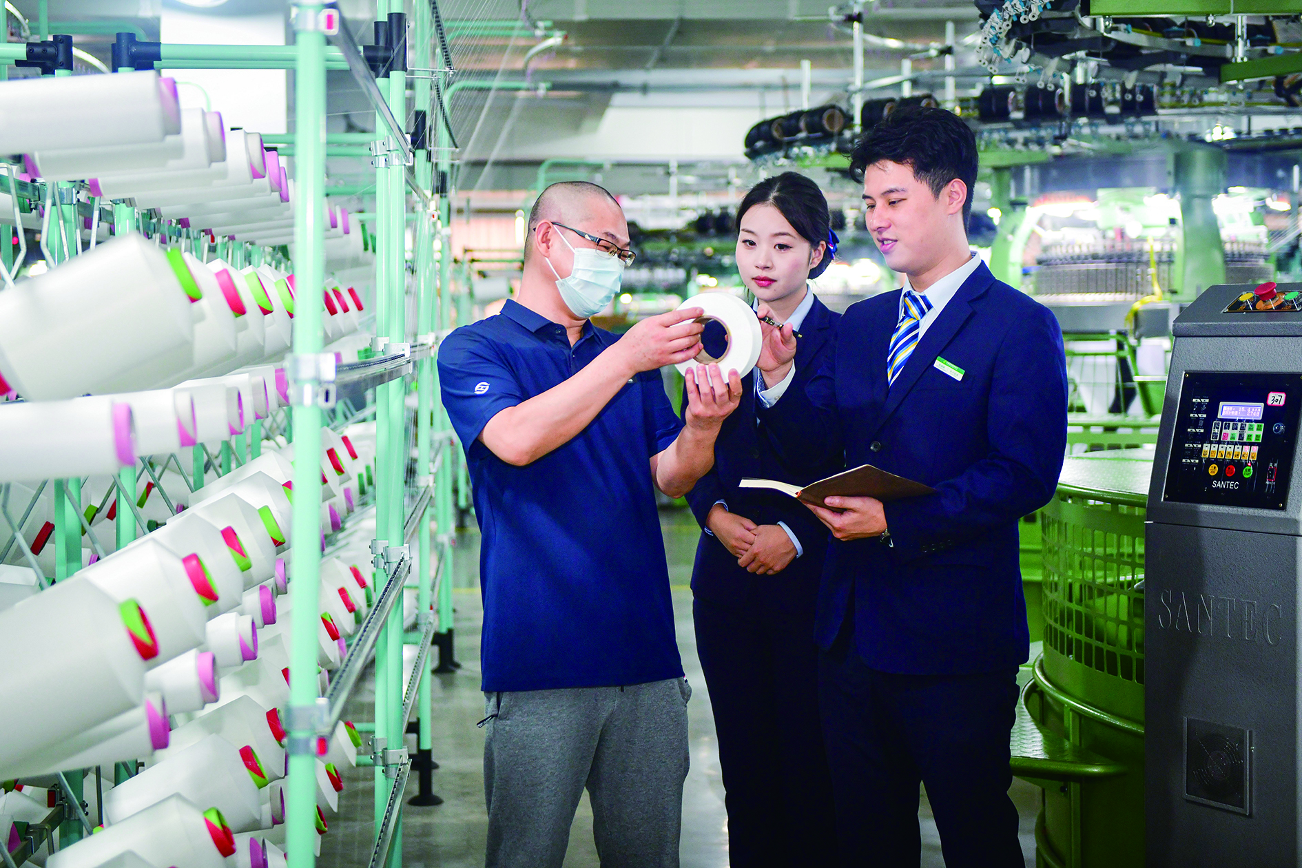 圖:郵儲銀行工作人員在紡織企業進行貸後回訪。