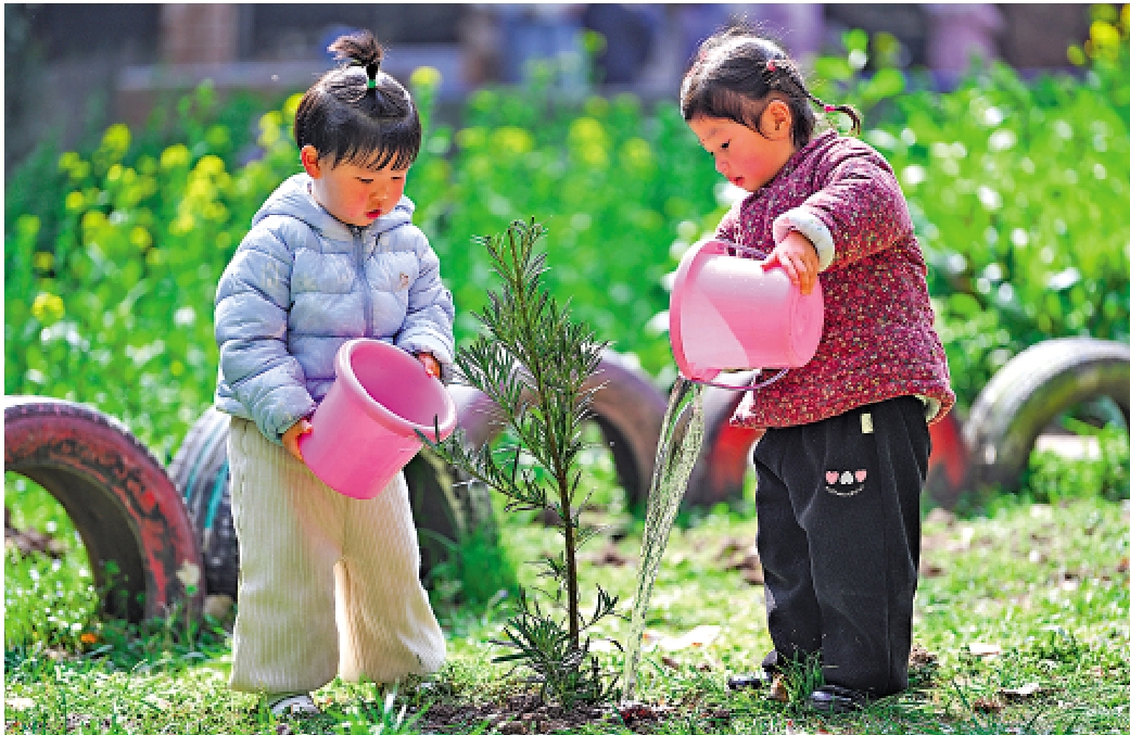 　　圖：植樹節之際，江蘇省南京市建鄴區金地名京幼兒園的孩子們為樹苗澆水。/新華社