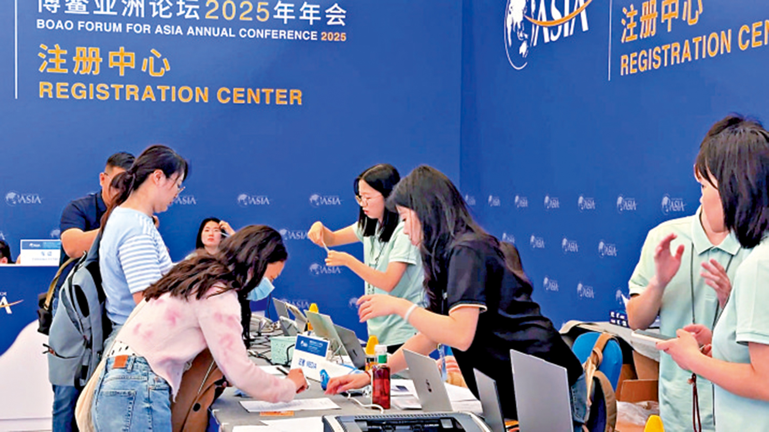 　　圖：與會記者在註冊中心領取證件及會議資料。\大公報記者黃寶儀攝