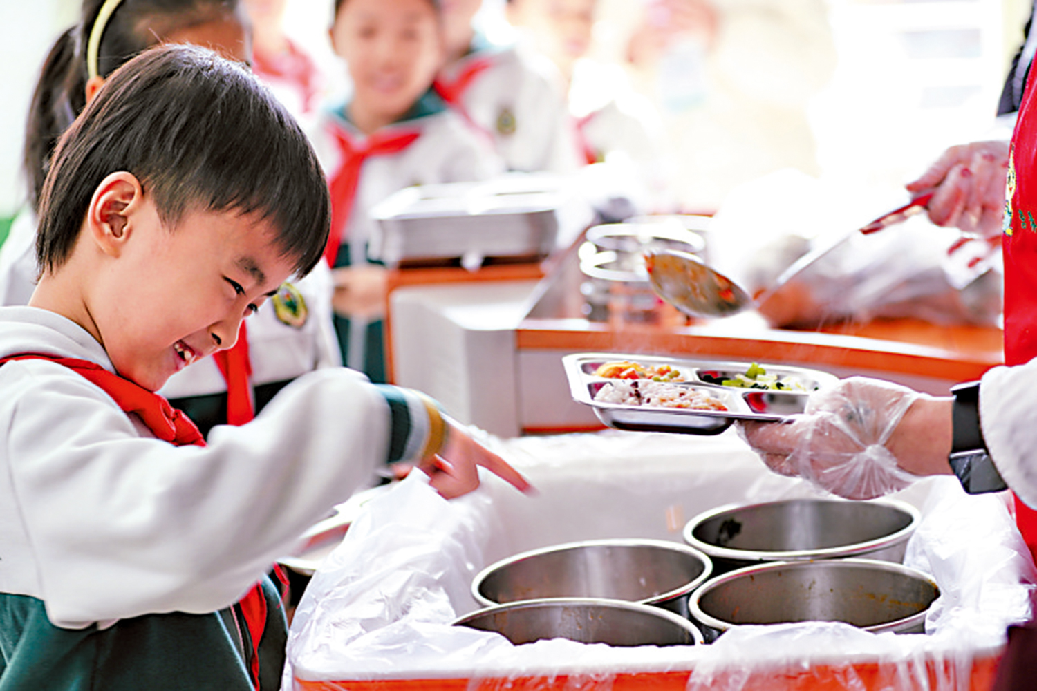 　　圖：北京市西城區廠橋小學的學生排隊領餐。\中新社