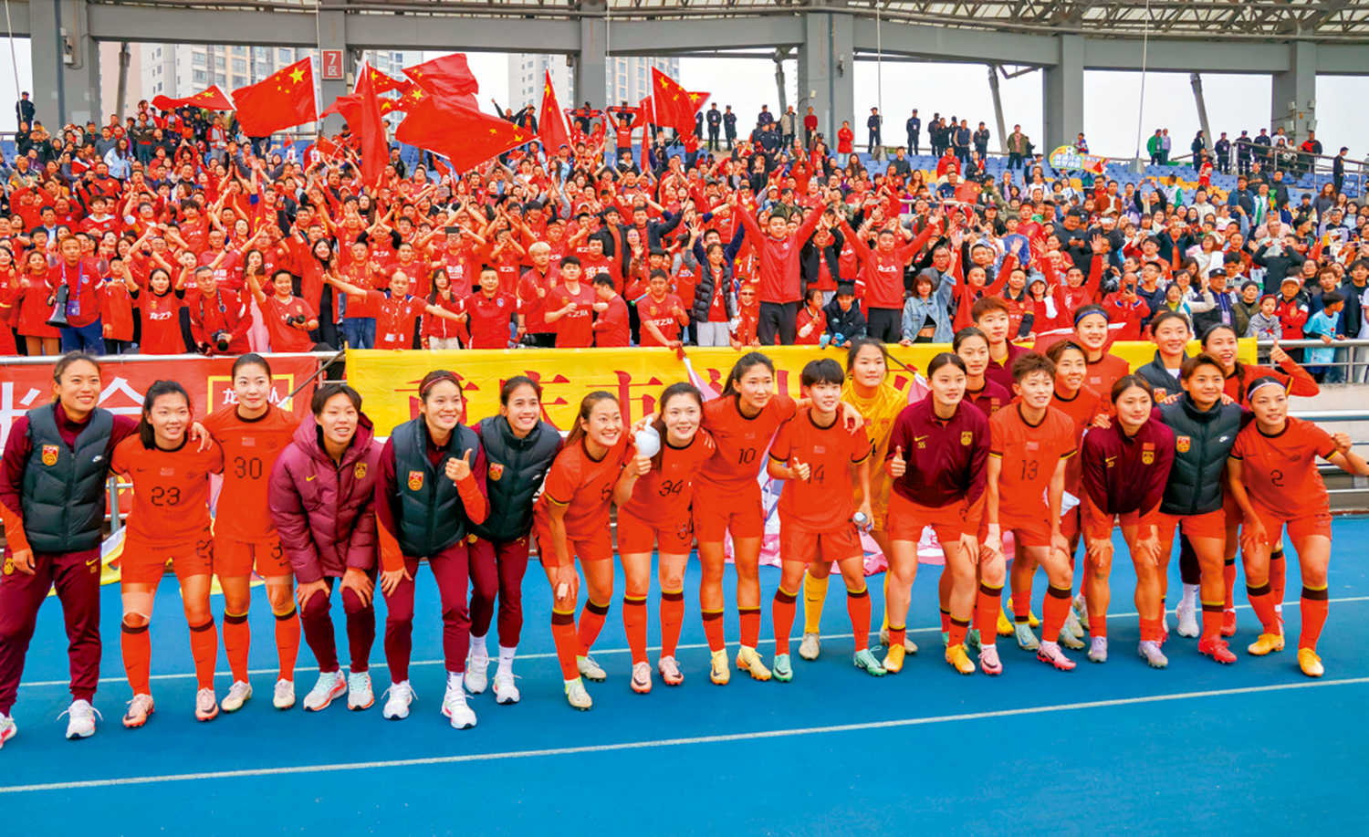 圖:中國女足球員在賽後與球迷合影。\新華社